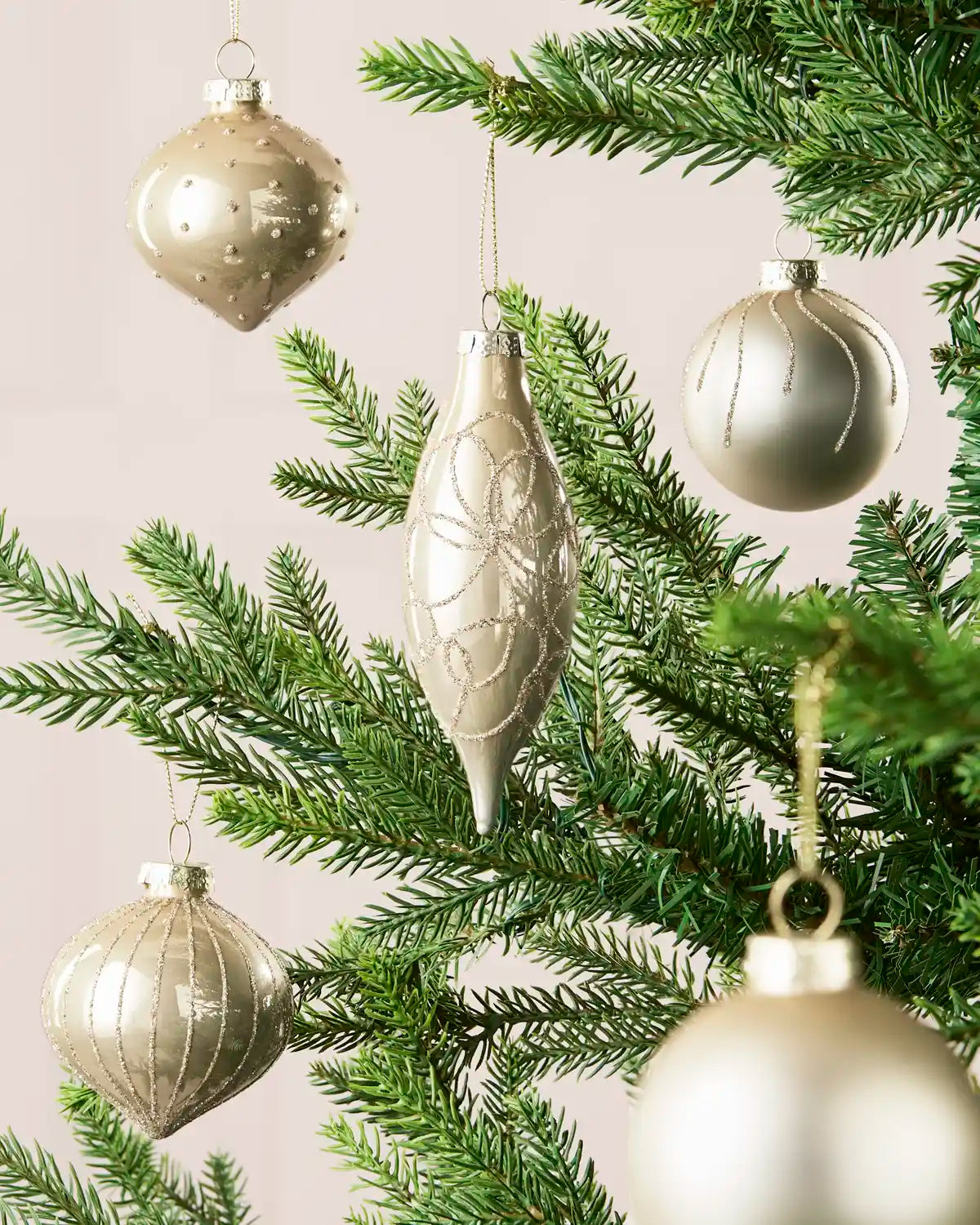 Mixed latte glass baubles with matt, shiny and glitter finishes on a Christmas tree.
