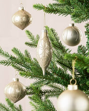 Mixed latte glass baubles with matt, shiny and glitter finishes on a Christmas tree.
