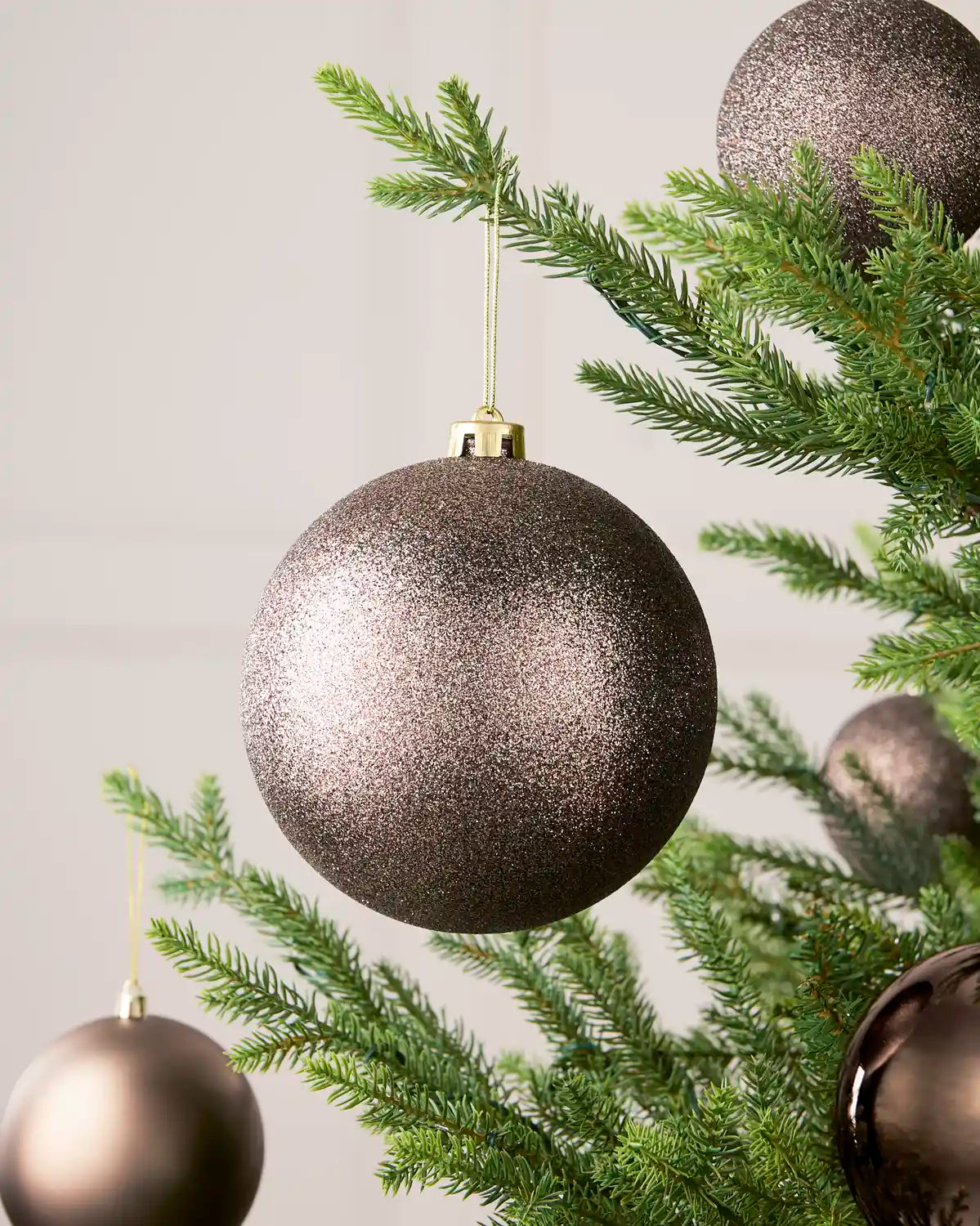 Mocha 15 cm oversized Glitter shatterproof bauble displayed on a Christmas tree with coordinating Mocha baubles.

