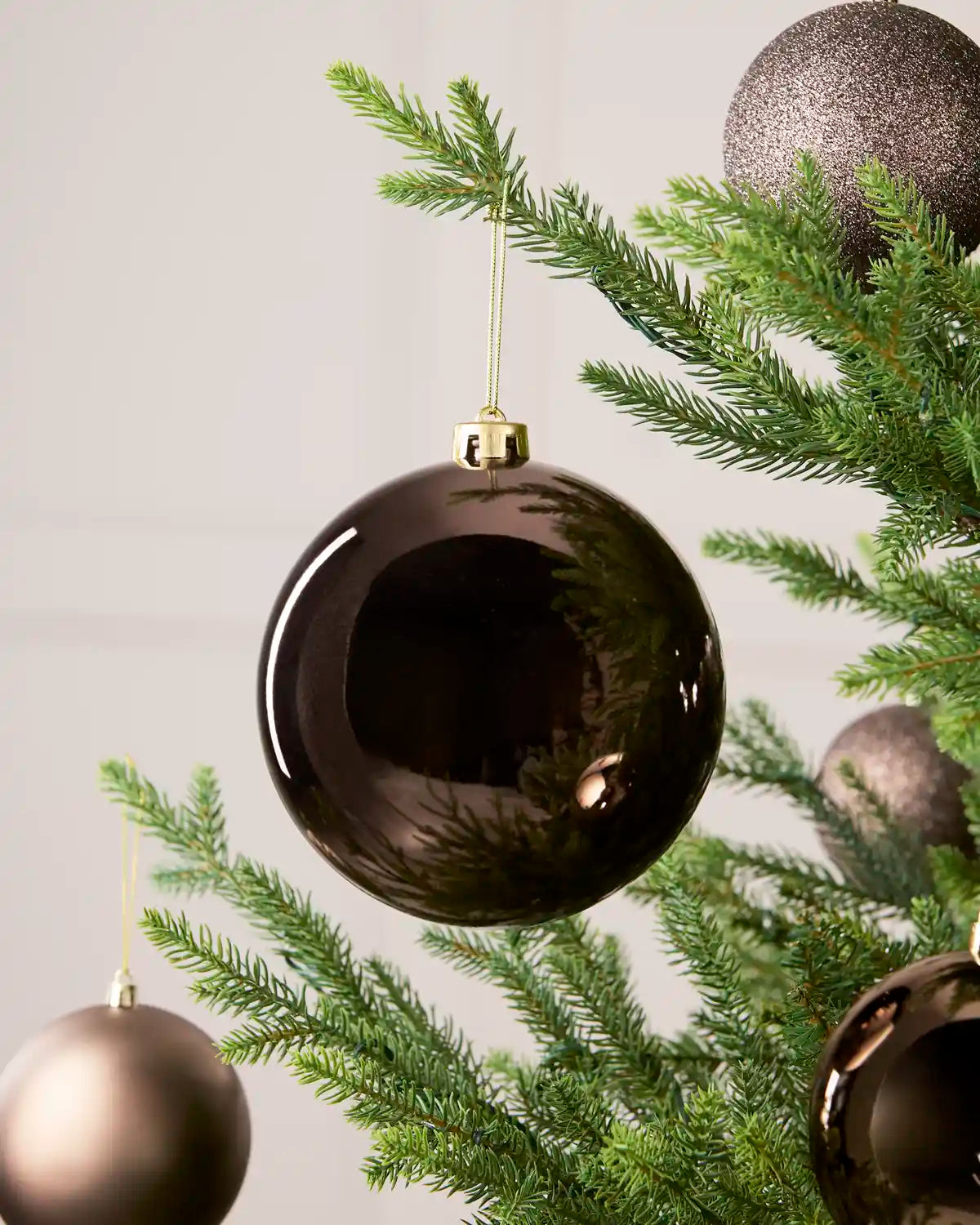 Mocha 15 cm oversized Shiny shatterproof bauble displayed on a Christmas tree with coordinating Mocha baubles.

