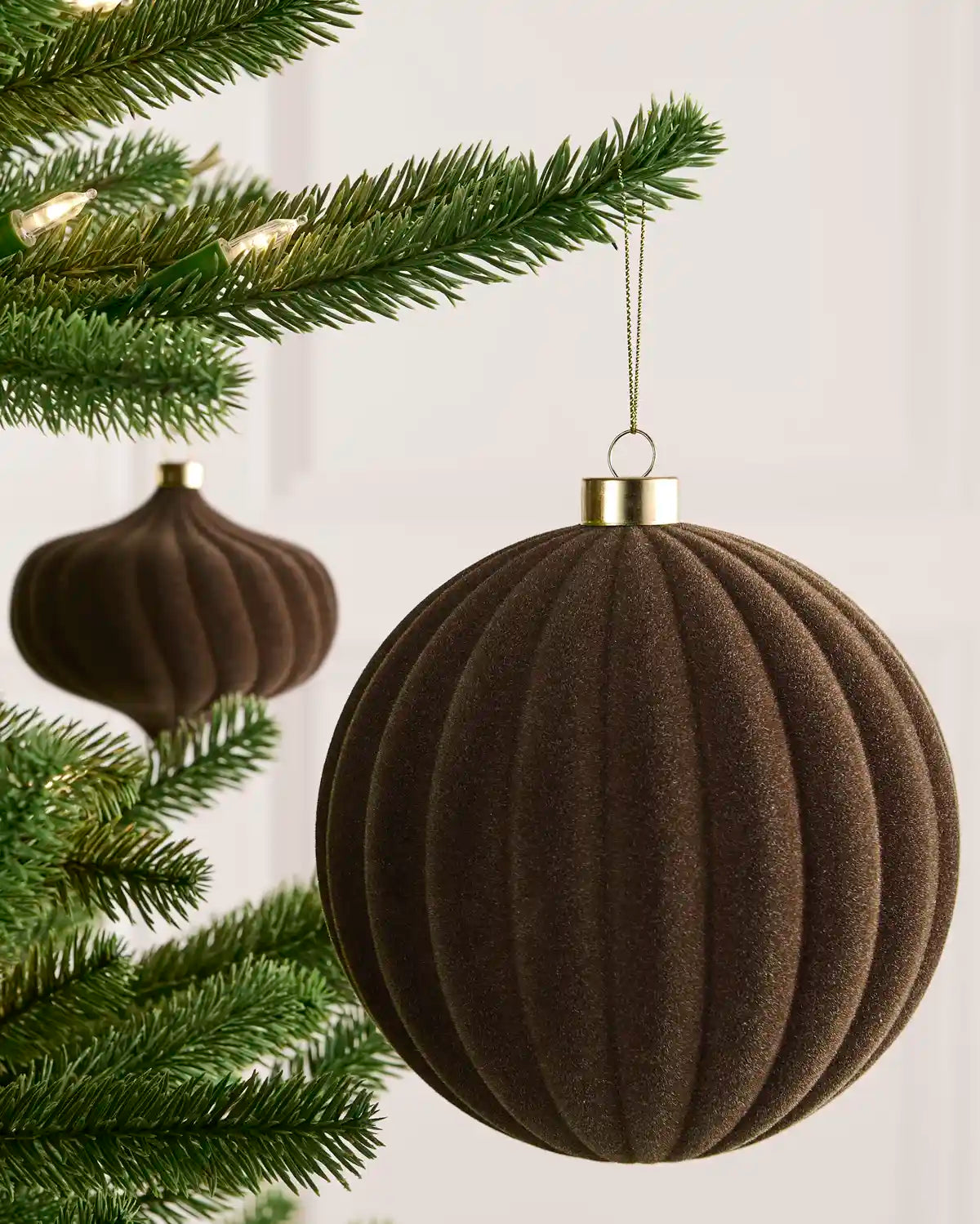 Mocha 15 cm oversized velvet Ribbed bauble displayed on a Christmas tree with coordinating ornaments.
