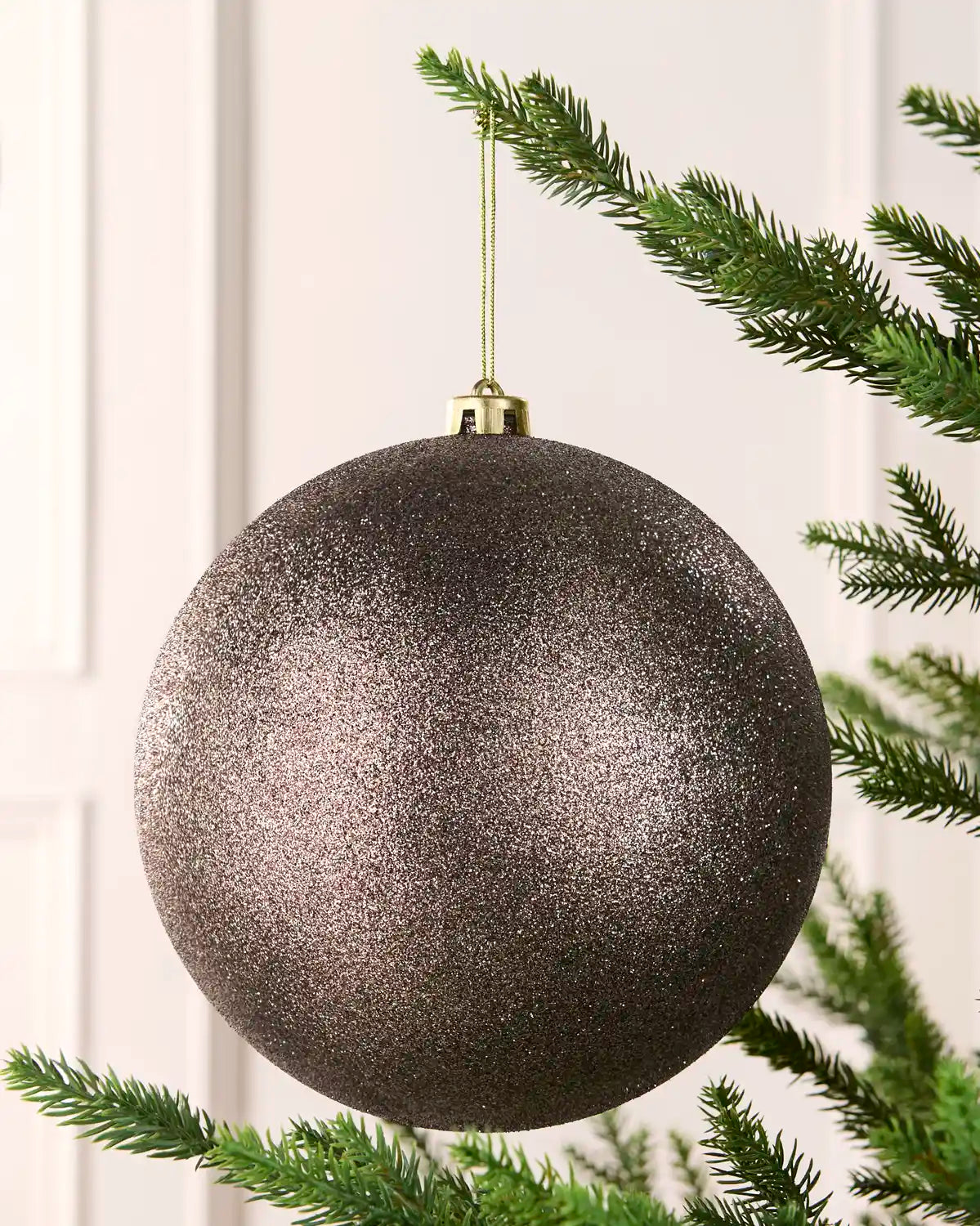 Mocha 20 cm oversized Glitter shatterproof bauble hanging on a Christmas tree with a gold cap and matching string.
