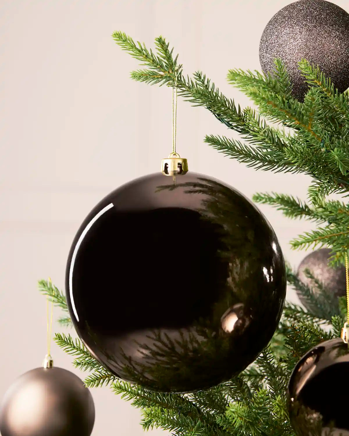 Mocha 20 cm oversized Shiny shatterproof bauble displayed on a Christmas tree with coordinating Mocha baubles.
