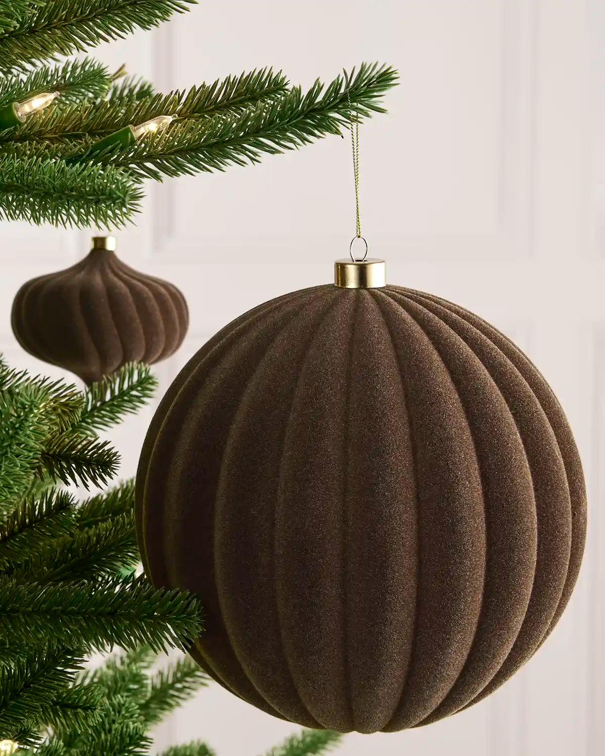 Mocha 20 cm oversized velvet Ribbed bauble displayed on a Christmas tree with coordinating ornaments.
