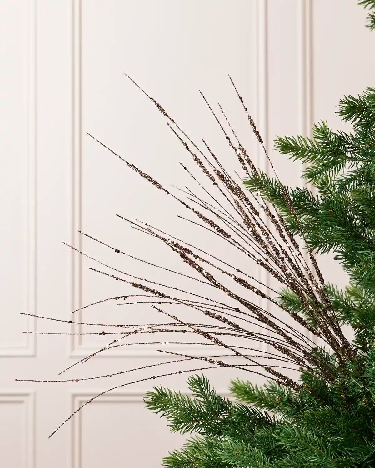 Mocha Glitter Wispy Spray with long, slender glitter-covered stems arranged in a fan shape on a Christmas tree
