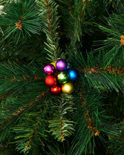 Multi coloured berry cluster baubles on a Christmas tree close up