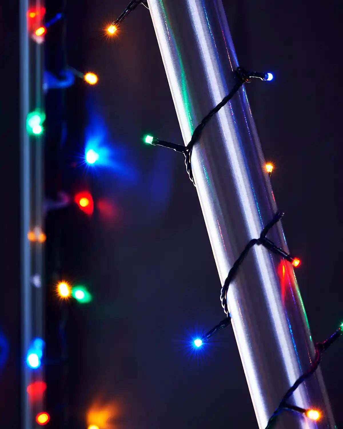 Multi coloured string lights on a metallic umbrella pole