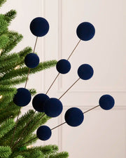 Navy Blue velvet bauble pick on a Christmas tree against a light background