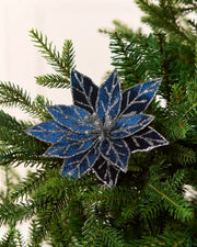 Navy blue glitter artificial poinsettia displayed on a Christmas tree