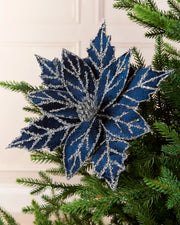 Navy blue glitter artificial poinsettia displayed on a Christmas tree