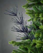 Navy blue glitter firework spray in tree in front of grey background