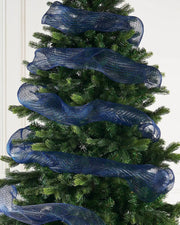 Navy blue mesh ribbon wrapped around a Christmas tree on a cream background