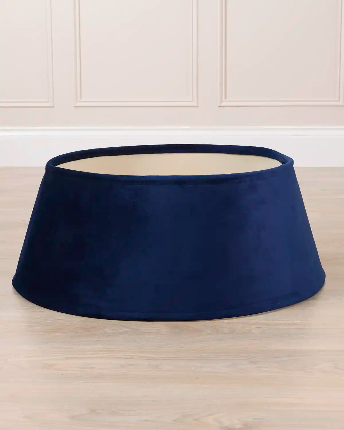 Navy velvet tree skirt displayed by itself, showing its circular shape, flared silhouette, and open center.