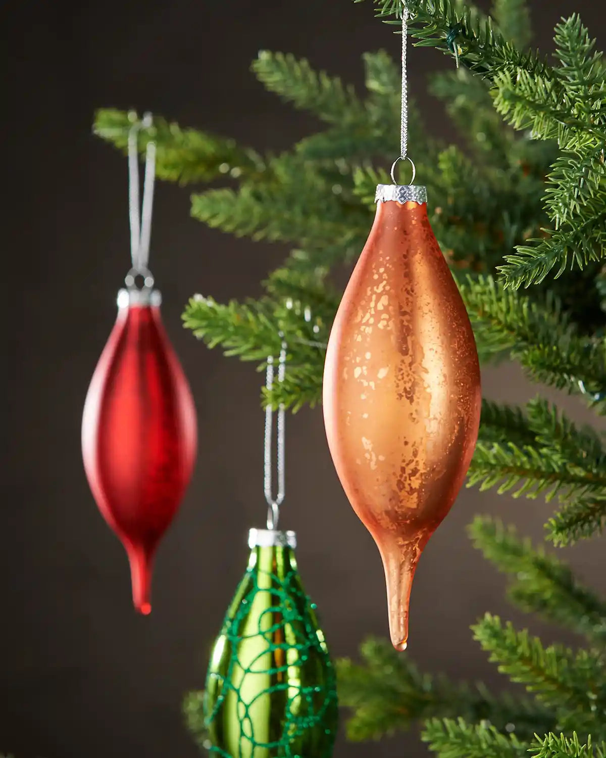 Orange, Green and Red, glass finial bauble hanging on Christmas tree