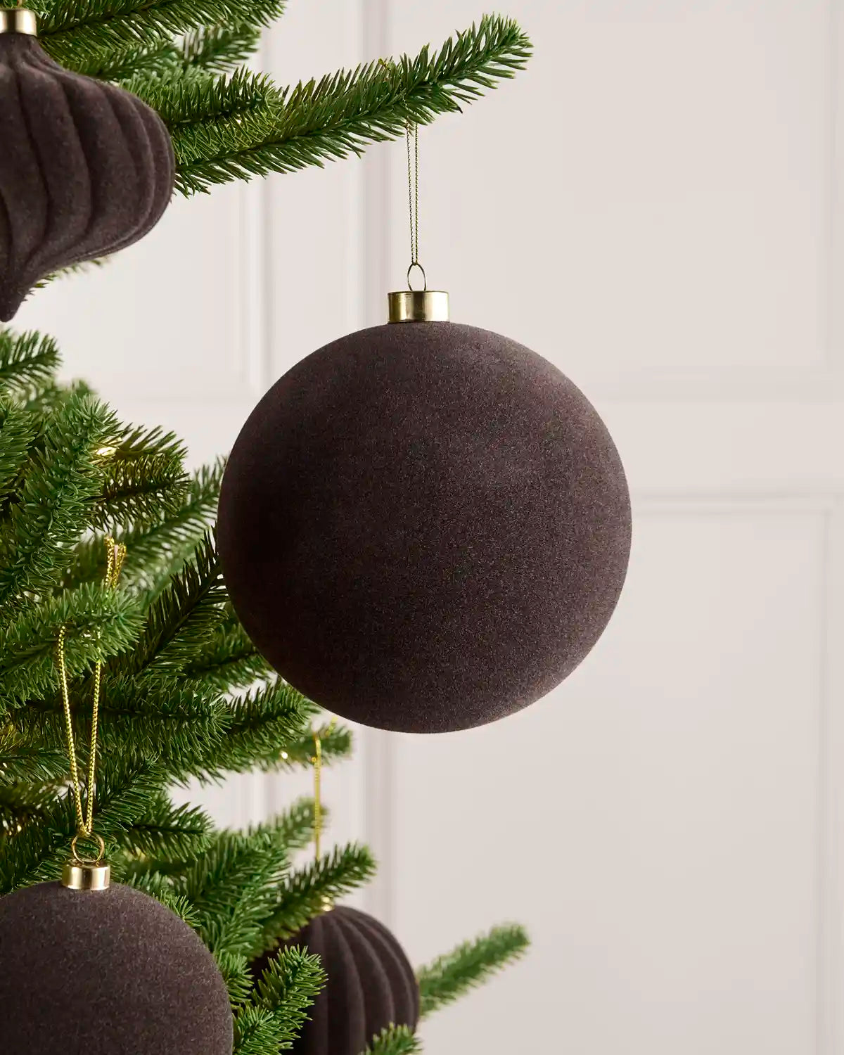 Oversized 15 cm Espresso velvet Traditional bauble styled among matching decorations on a Christmas tree.
