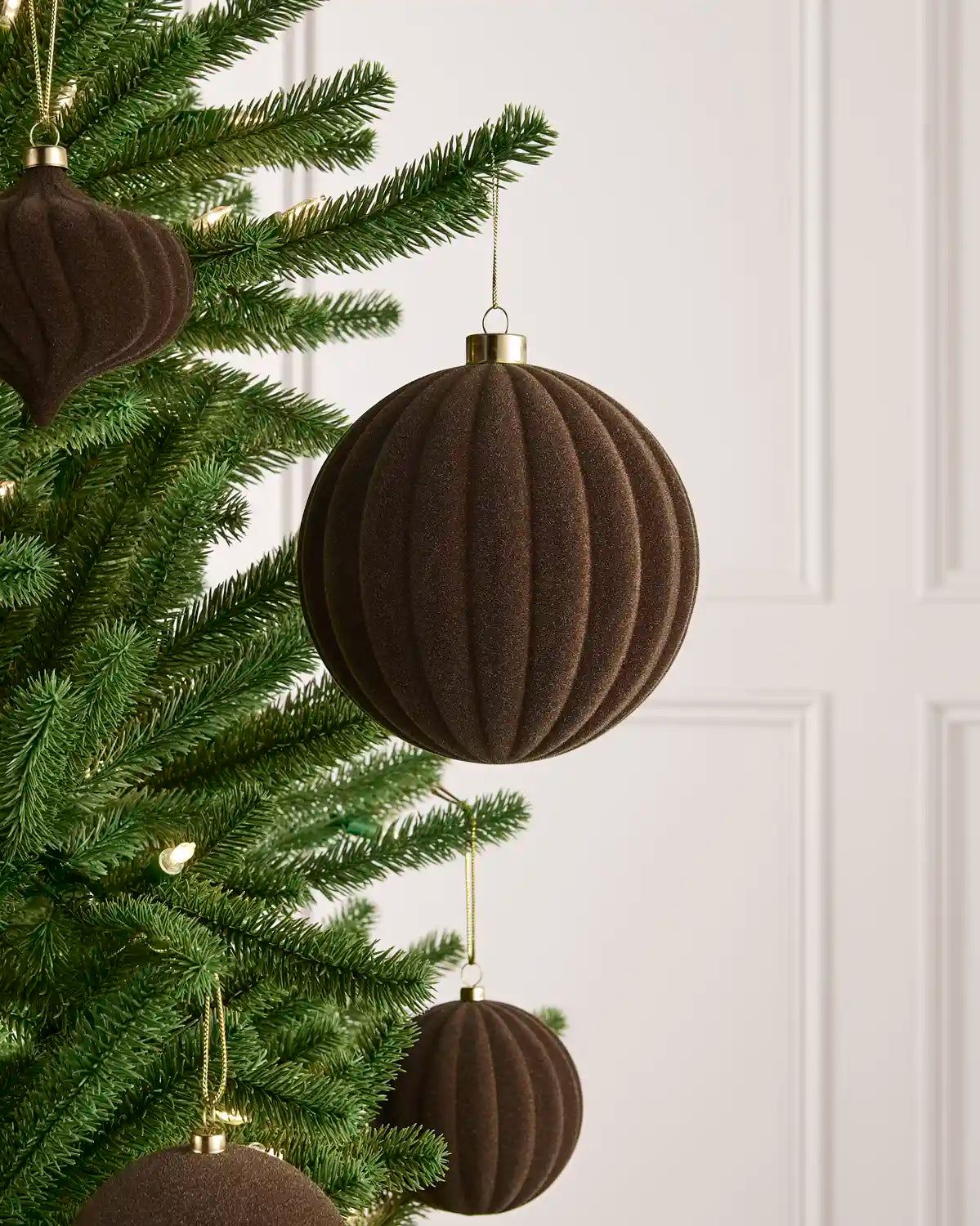 Oversized 15 cm Mocha velvet Ribbed bauble styled among matching decorations on a Christmas tree.
