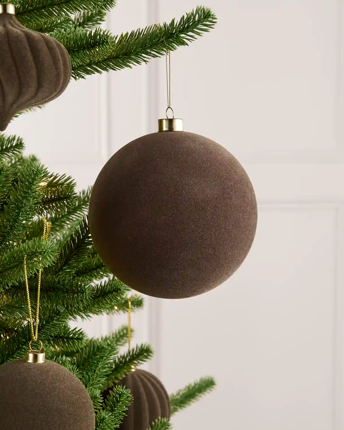 Oversized 15 cm Mocha velvet Traditional bauble styled among matching decorations on a Christmas tree.
