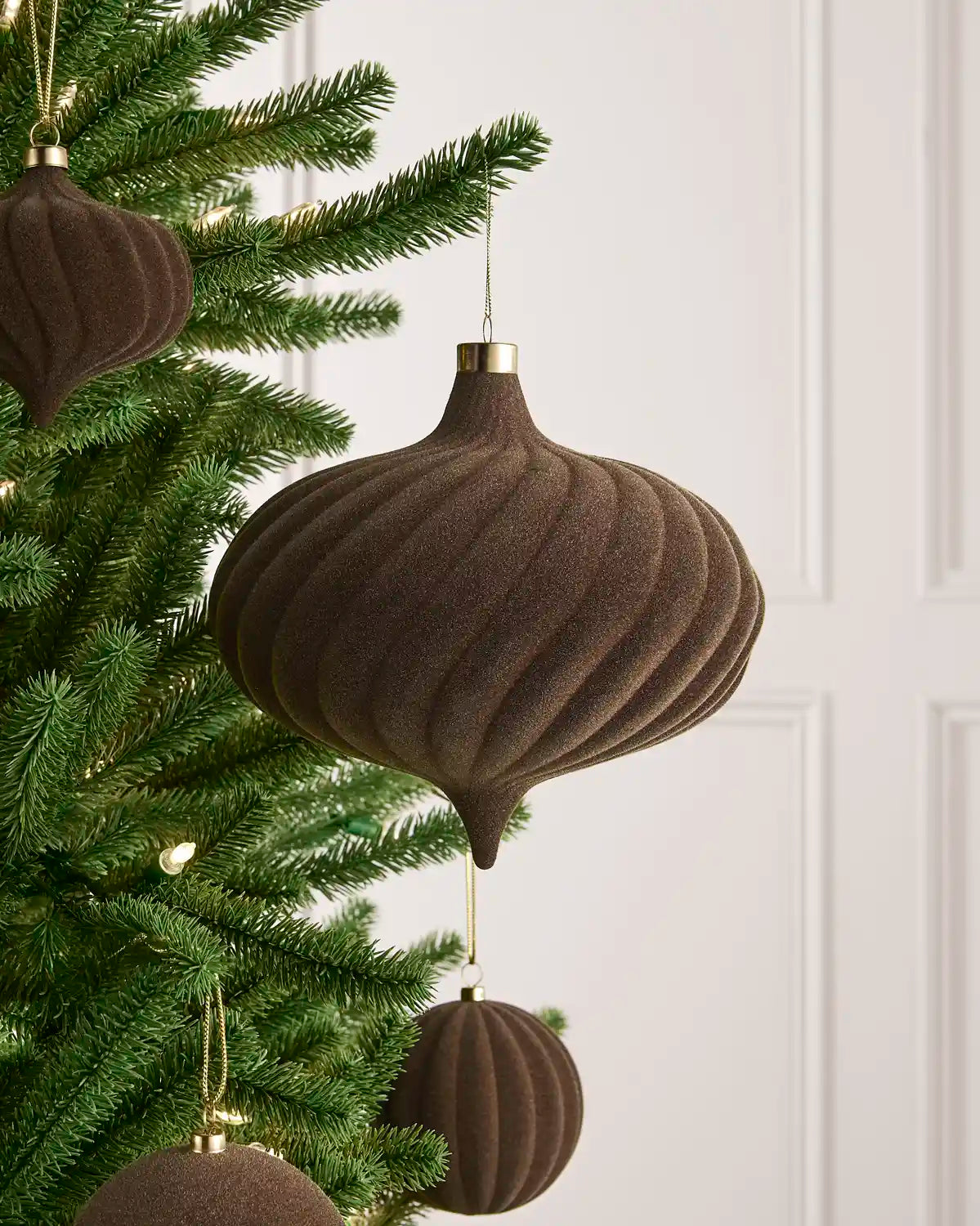 Oversized 20 cm Mocha velvet Spiral bauble styled among matching decorations on a Christmas tree.
