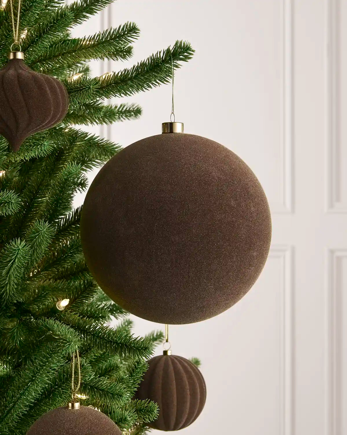 Oversized 20 cm Mocha velvet Traditional bauble styled among matching decorations on a Christmas tree.
