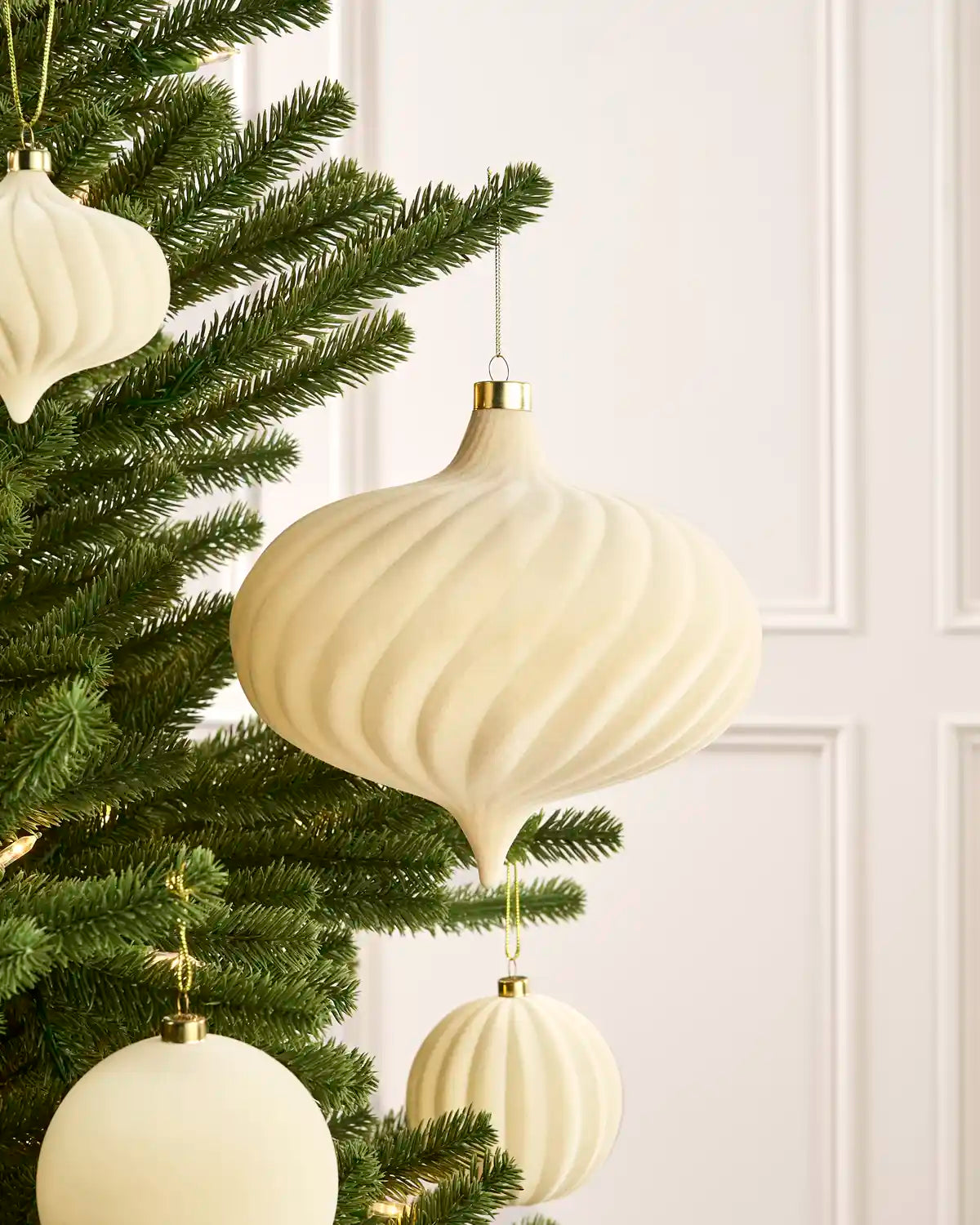 Oversized 20 cm latte velvet Spiral bauble styled among matching decorations on a Christmas tree.
