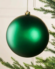 Oversized Christmas green matt bauble on a Christmas tree branch