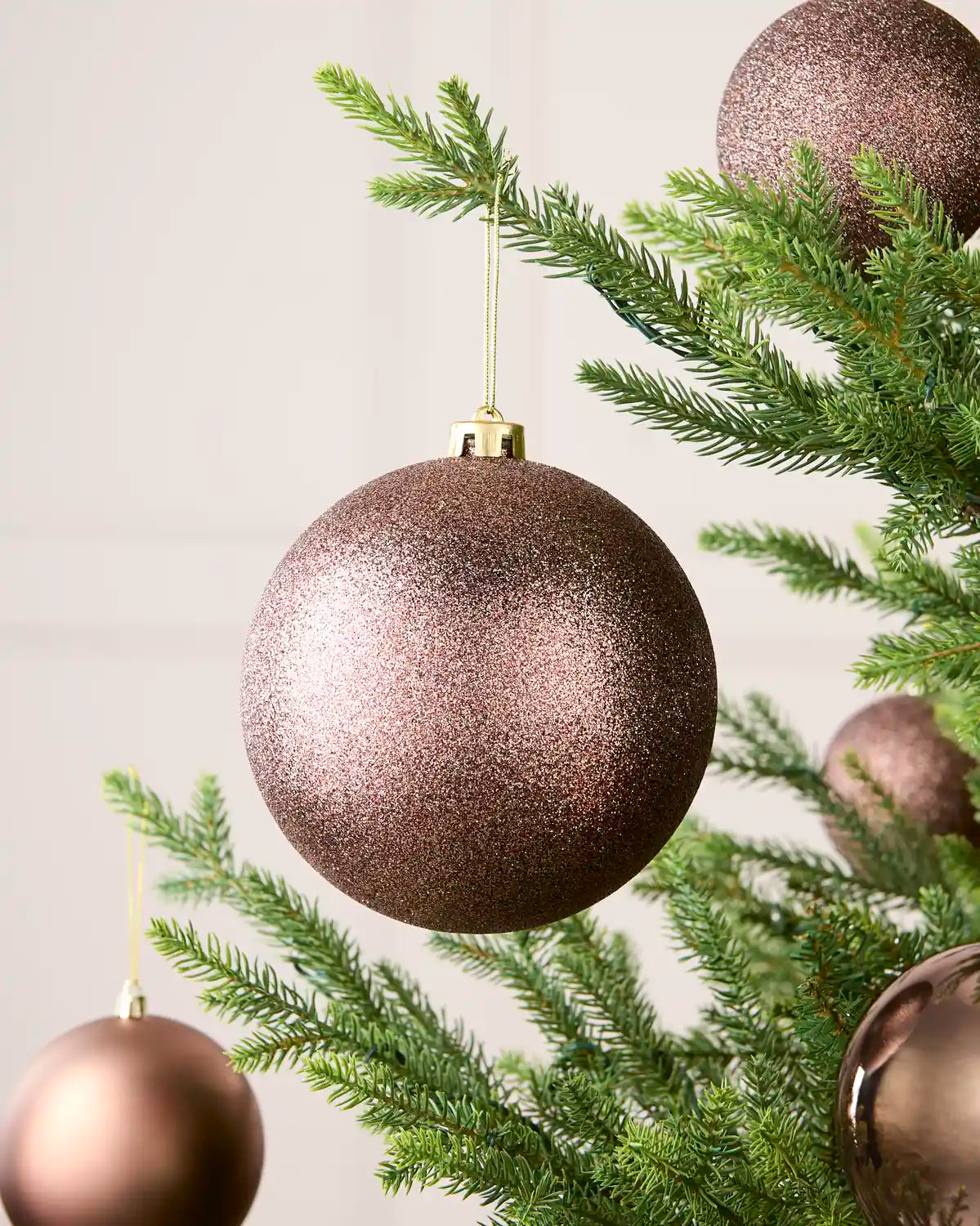Oversized glitter bauble with four smaller baubles on a Christmas tree