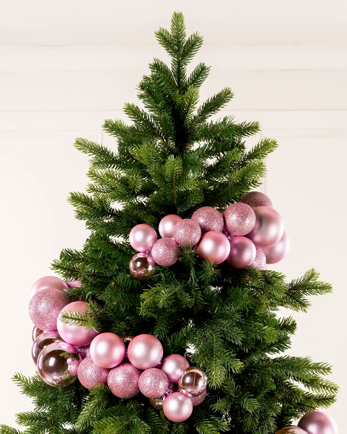 Pink Bauble Cluster Arch wrapped around a Christmas tree, showing clusters of pink baubles in different sizes and finishes