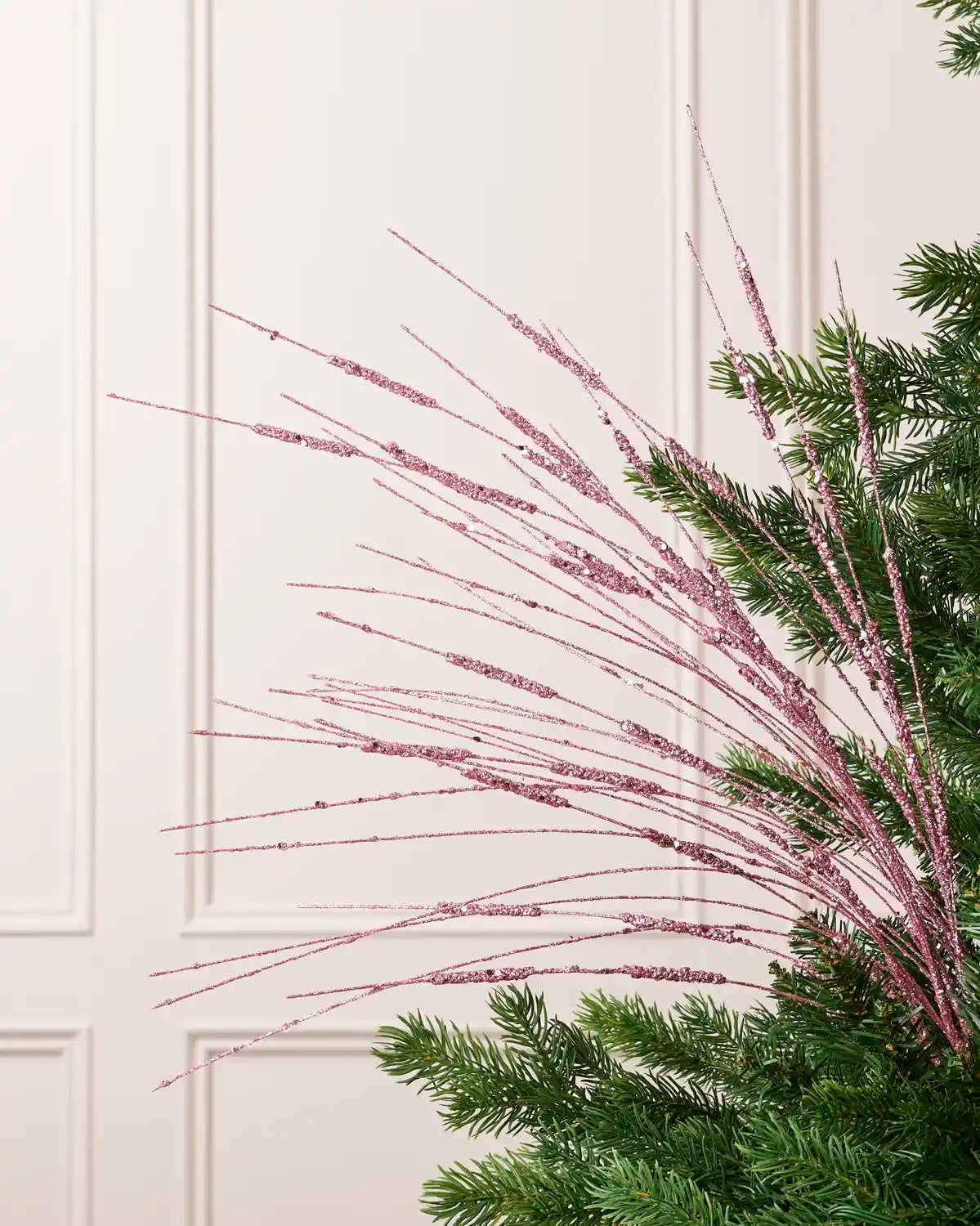 Pink Glitter Wispy Spray with long, slender glitter-covered stems arranged in a fan shape on a Christmas tree
