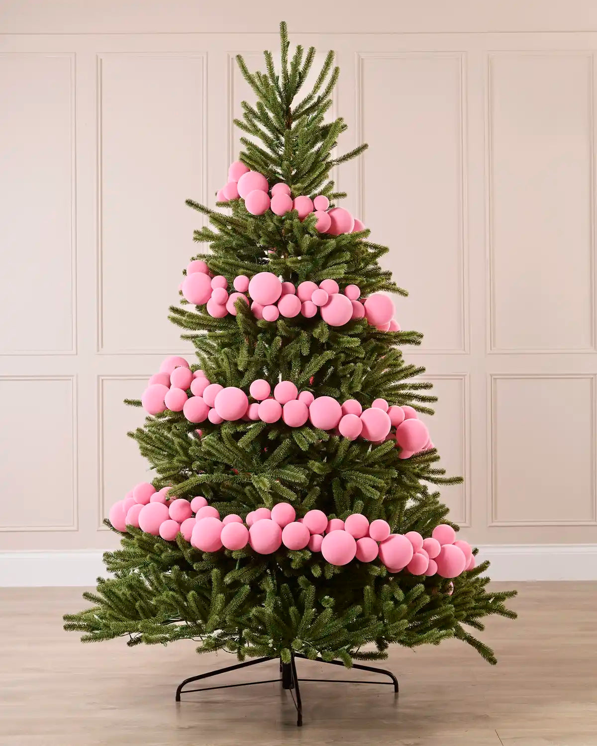 Pink Velvet Bauble Garland decorating a Christmas tree, featuring pink velvet baubles arranged along the garland.