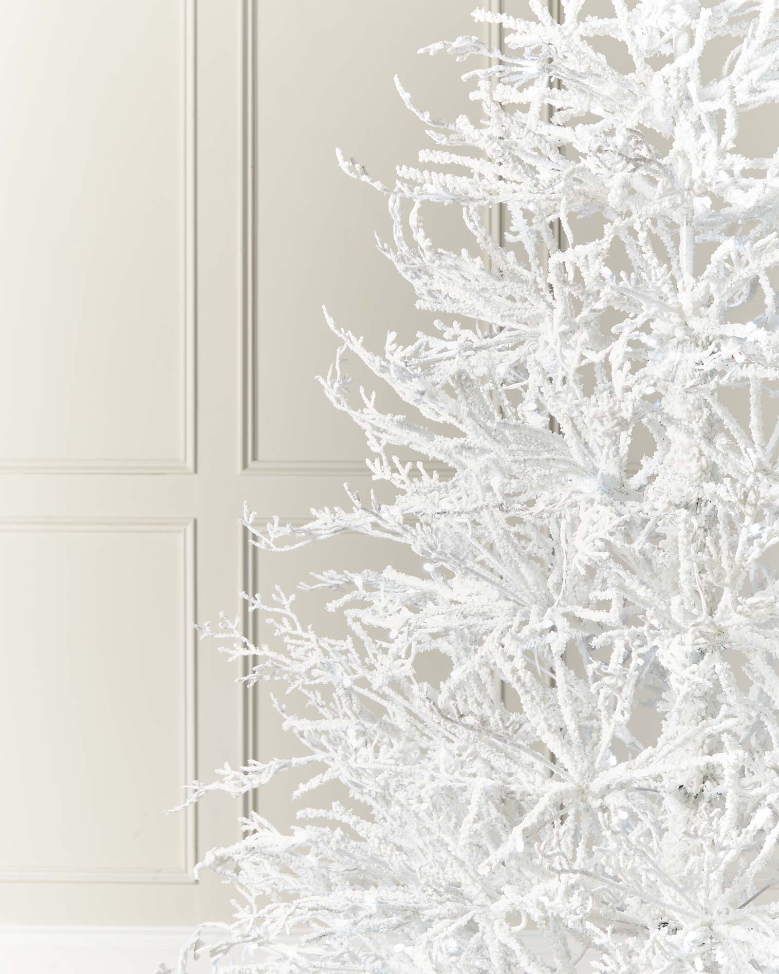 Minimalistic pre-lit white Arctic Ice Twig Christmas tree with snow-flocked PE/PVC branches, glowing with bright white LED lights against a neutral wall—crafted for easy setup and timeless winter charm.