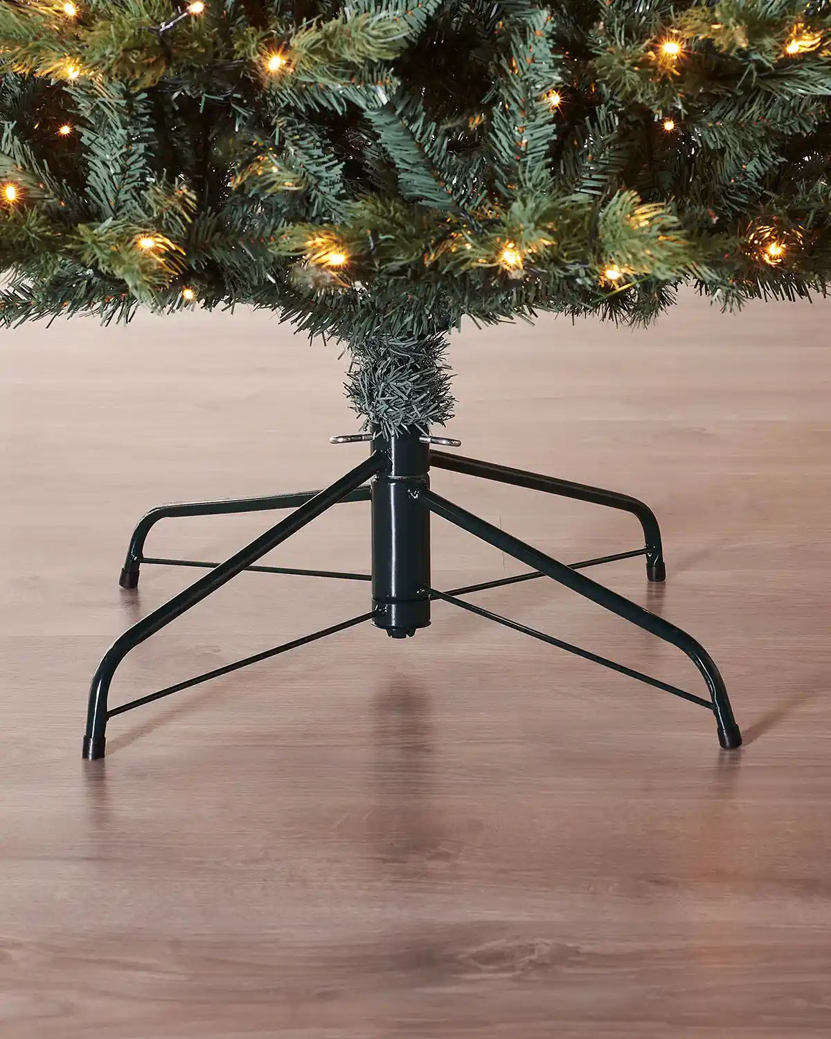 Pre-Lit Colorado Blue Spruce Christmas Tree with lights, 7 ft close up of base of tree and Black tree stand