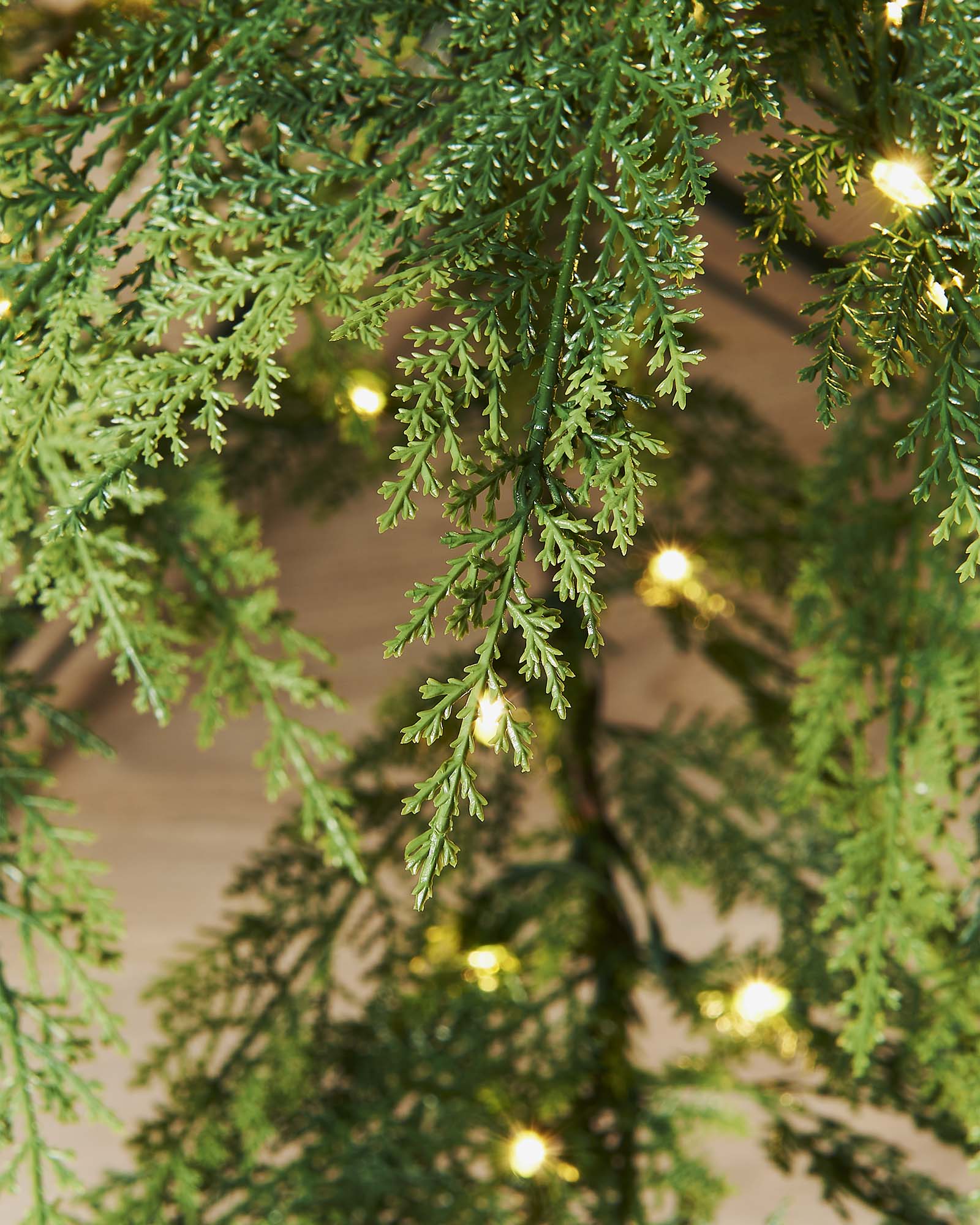 A pre-lit Cypress Fir Christmas tree with green branches and white lights, displayed against a neutral background.