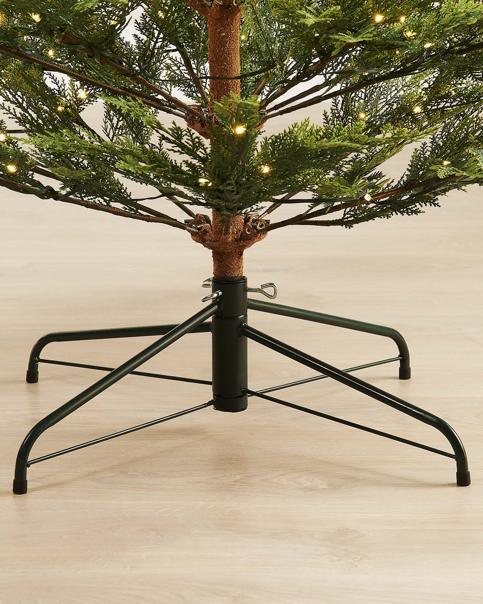 A pre-lit Cypress Fir Christmas tree with green branches and white lights, displayed against a neutral background.