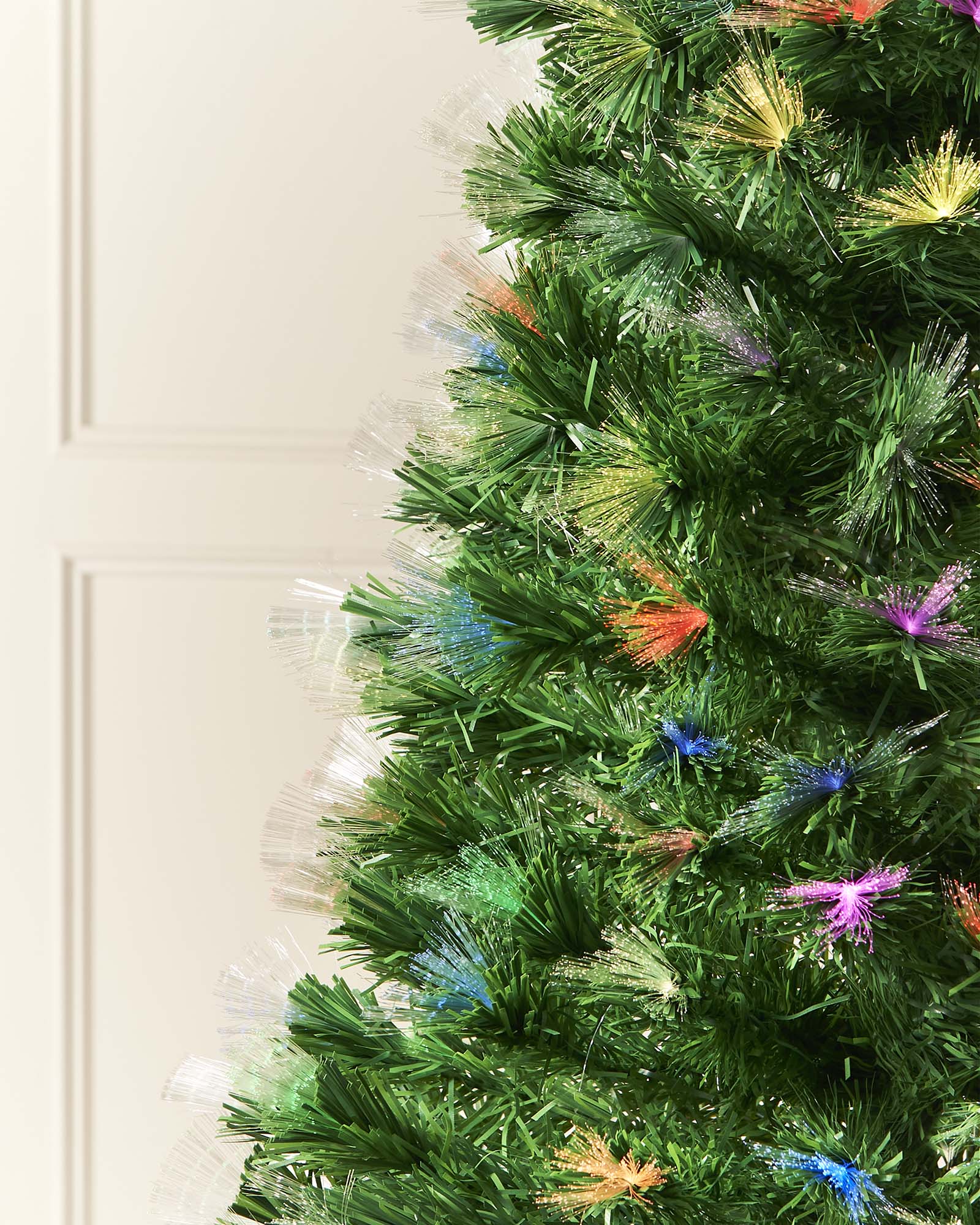 A pre-lit fiber optic Christmas tree with a tree topper, standing upright against a plain background.