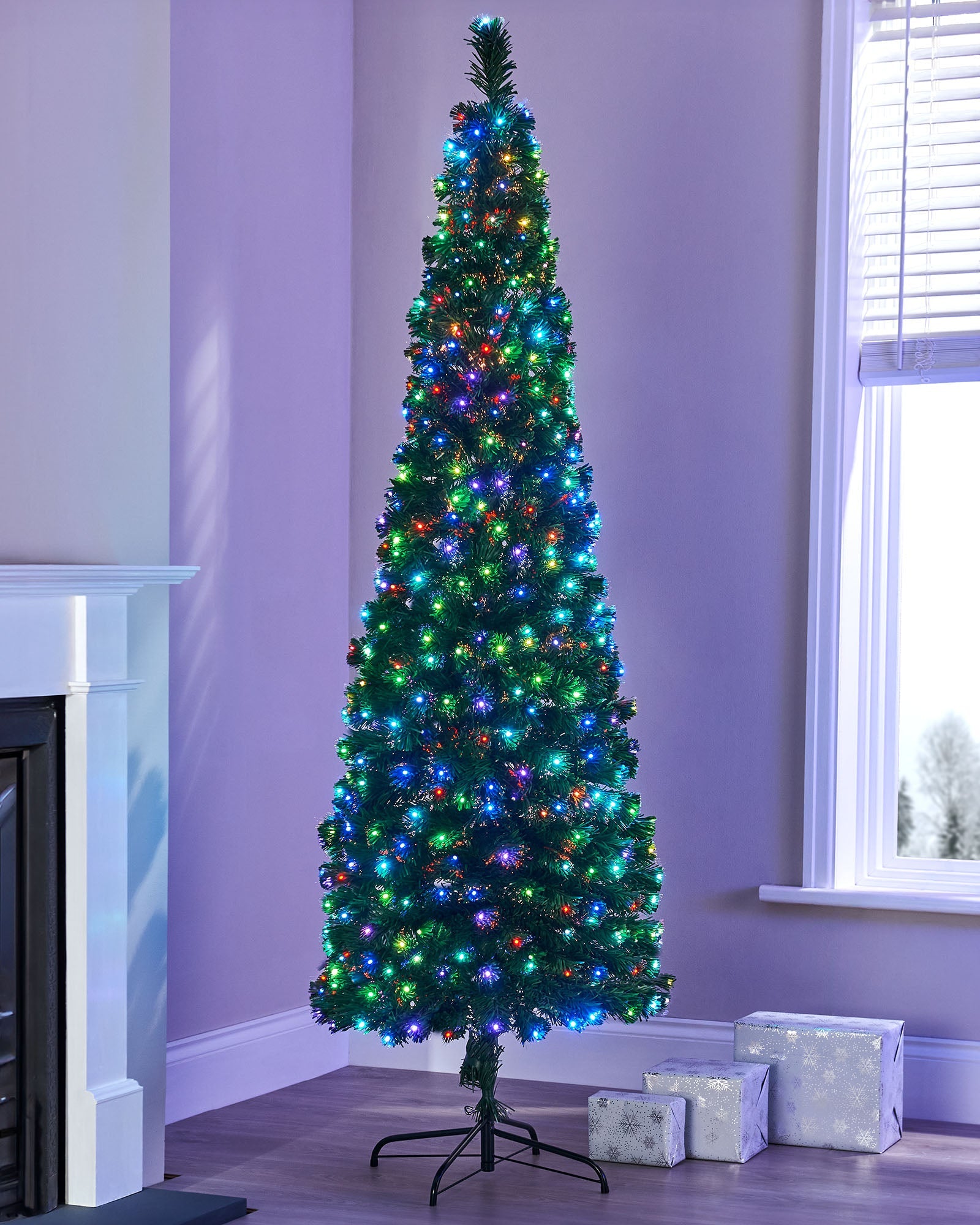 6-foot pre-lit Christmas tree with 248 multi-coloured fibre optic tips and 248 multi-coloured LEDs, featuring 8 lighting functions, displayed indoors with a compact 70 cm diameter.