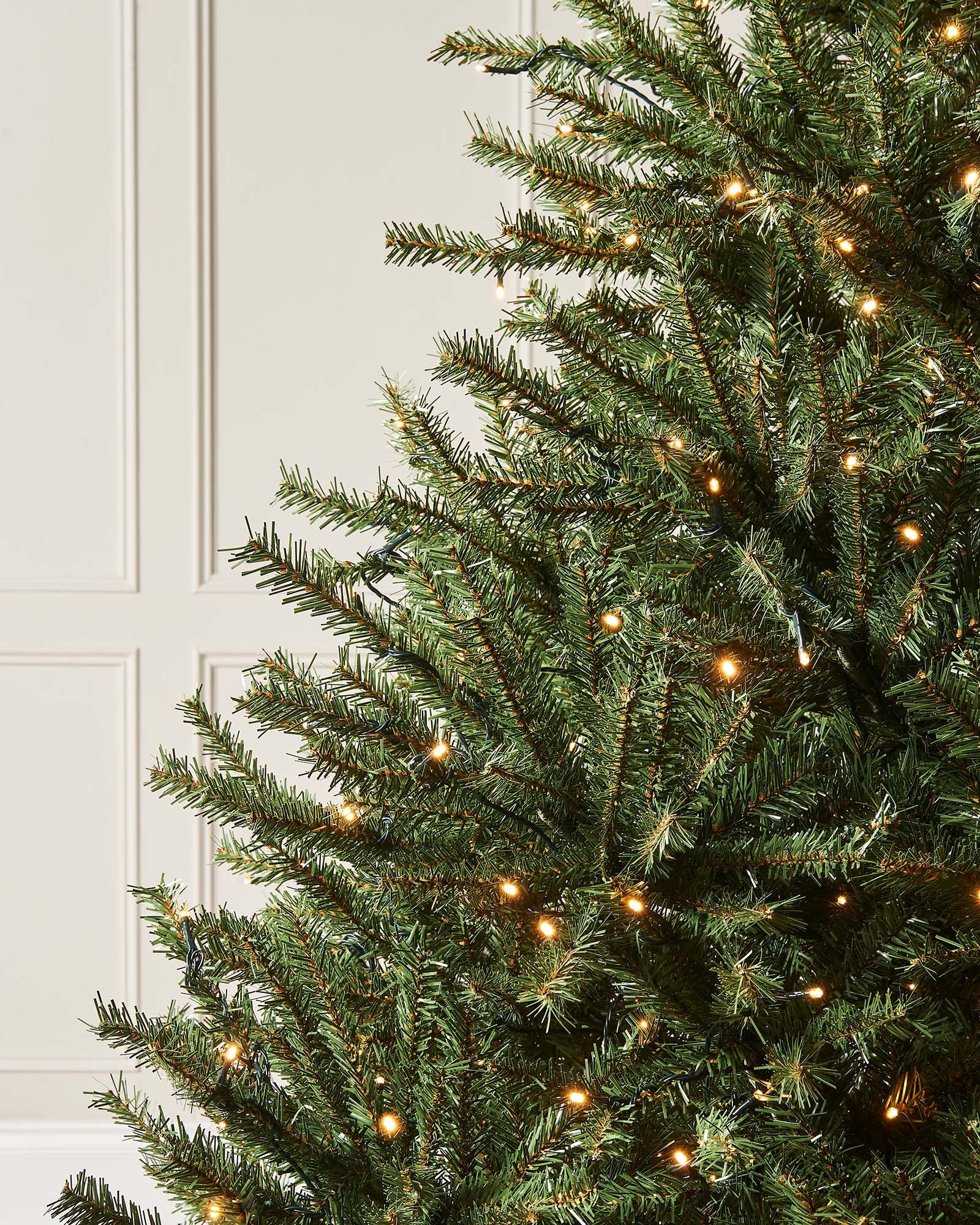 Pre-lit Foxtail Pine Christmas tree with warm white LED lights and V-cut tips, featuring a realistic tinsel bark effect, displayed against a plain background.