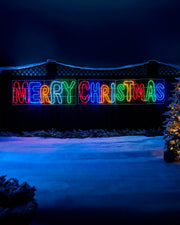 Pre-Lit Merry Christmas, Multi-Coloured, Silhouette, 292 cm on a garden fence with snow on the ground at night time