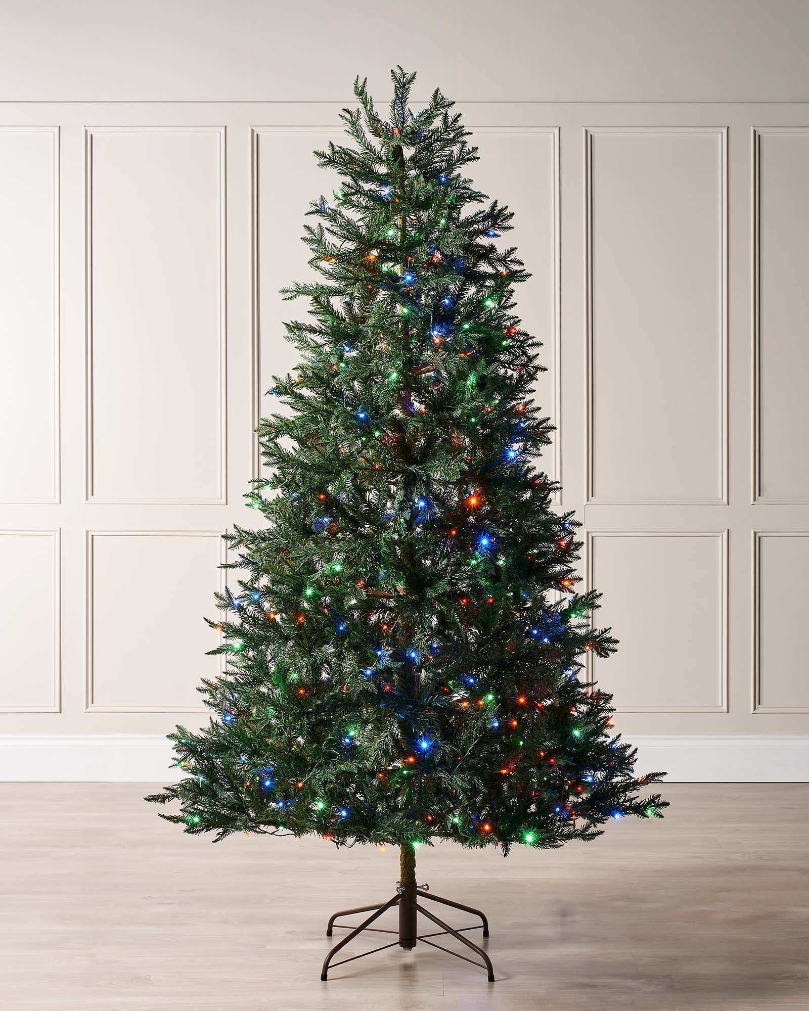 5-foot pre-lit mixed pine Christmas tree with natural bark trunk and dual LED lights in warm white and multicolour, displayed indoors against a neutral background.