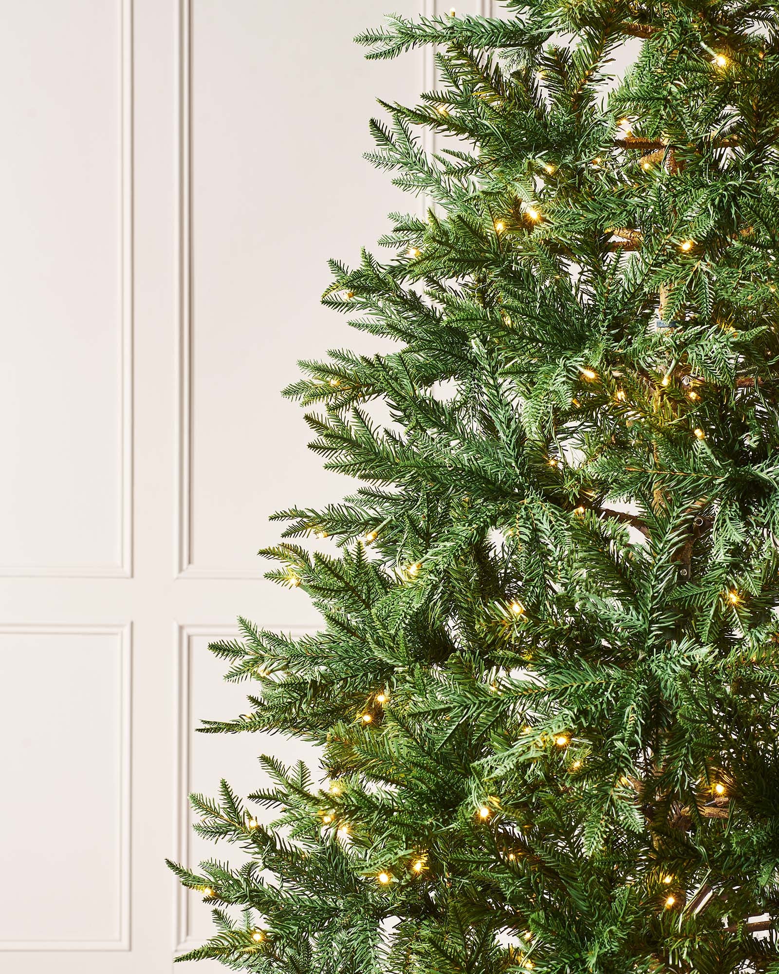 5-foot pre-lit mixed pine Christmas tree with natural bark trunk and dual LED lights in warm white and multicolour, displayed indoors against a neutral background.
