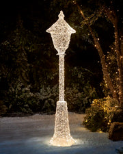 Pre-Lit Twinkling Beaded Lamp Post glowing with warm white lights in a snowy outdoor garden at night