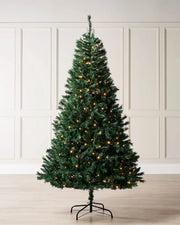 Pre-lit 8ft Christmas tree white warm white lights against a cream panel wall
