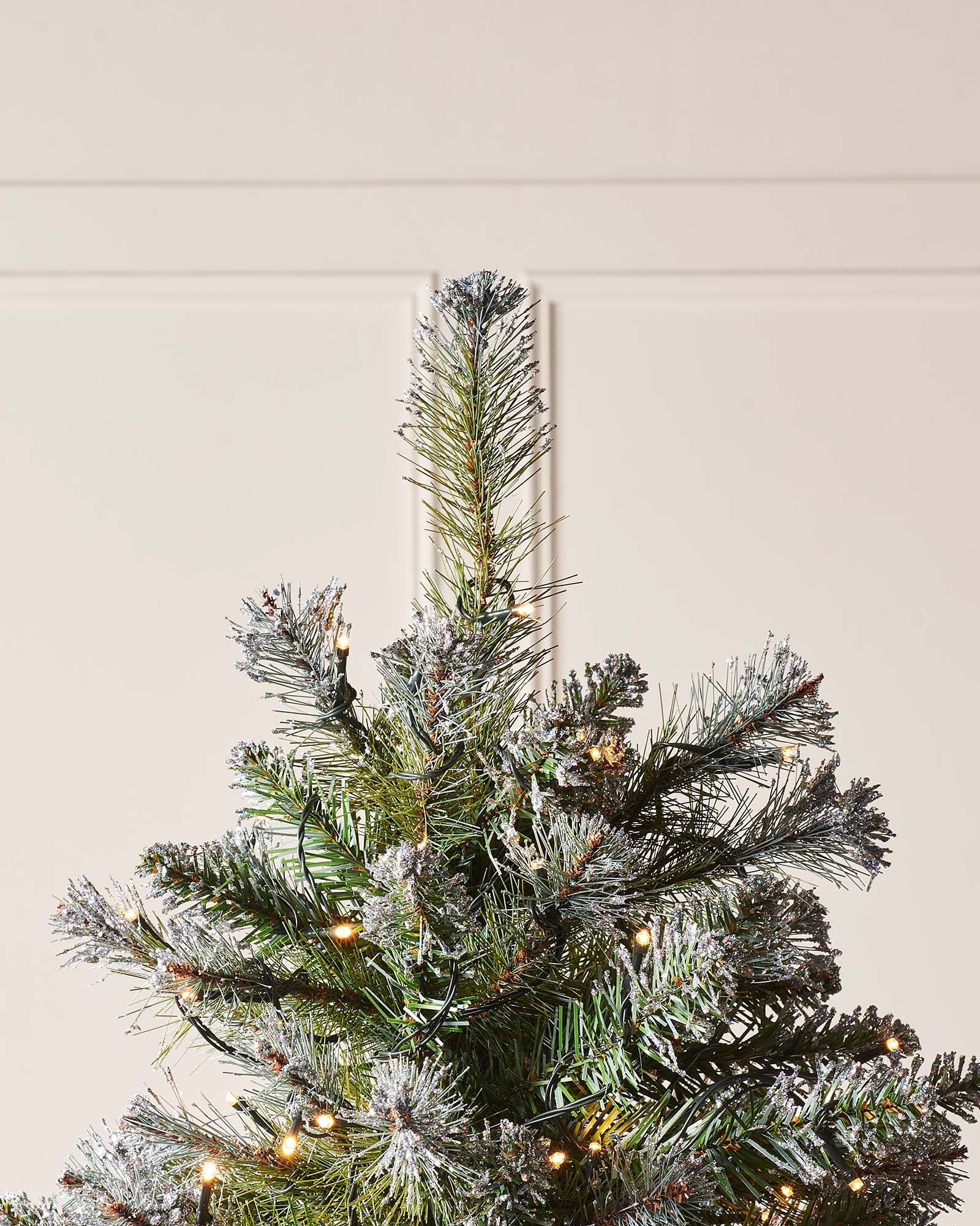 Pre-lit Blue Brockton Spruce Christmas tree with lifelike PE/PVC branches, pinecones, warm white multicolor LED lights, and a glitter finish—indoor tree with low voltage transformer for safe, energy-efficient festive brilliance.