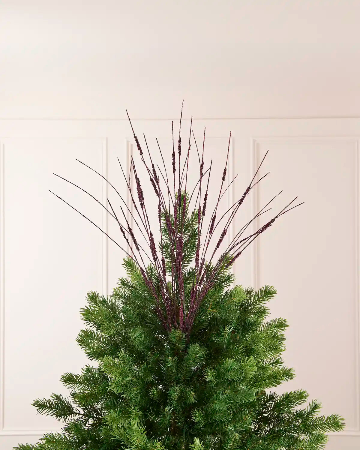 Purple Glitter Wispy Spray displayed at the top of a Christmas tree, with thin glitter-covered stems extending upward and outward