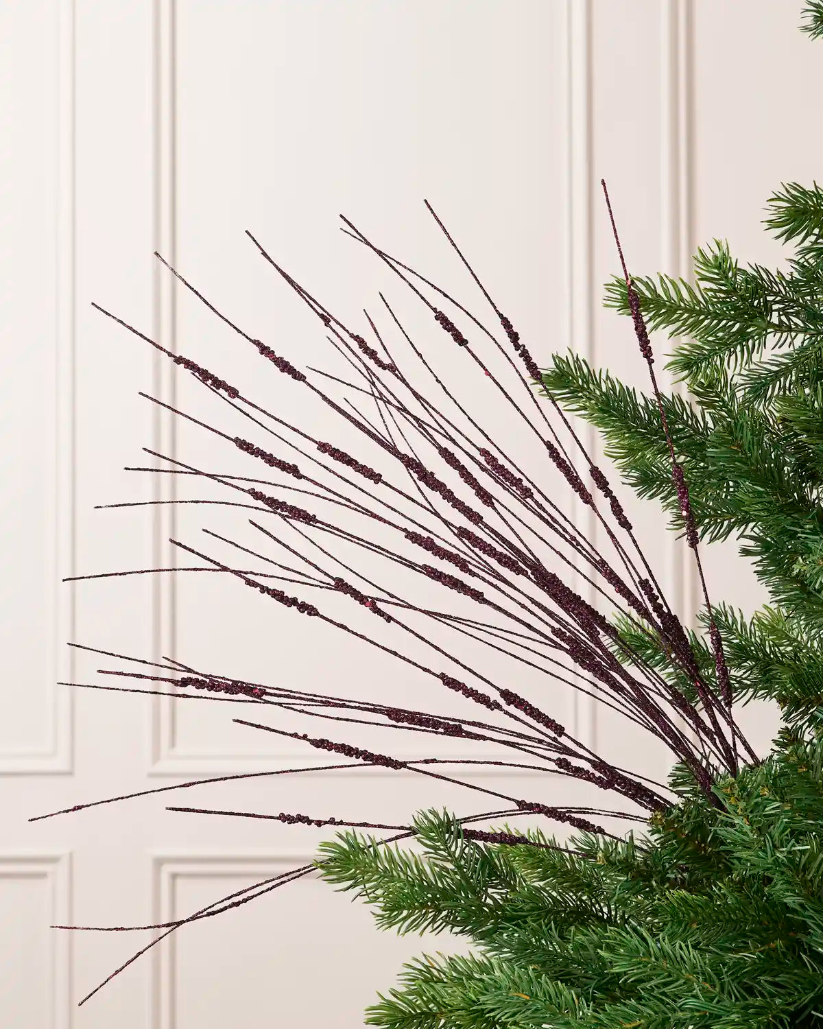 Purple Glitter Wispy Spray with long, slender glitter-covered stems arranged in a fan shape on a Christmas tree