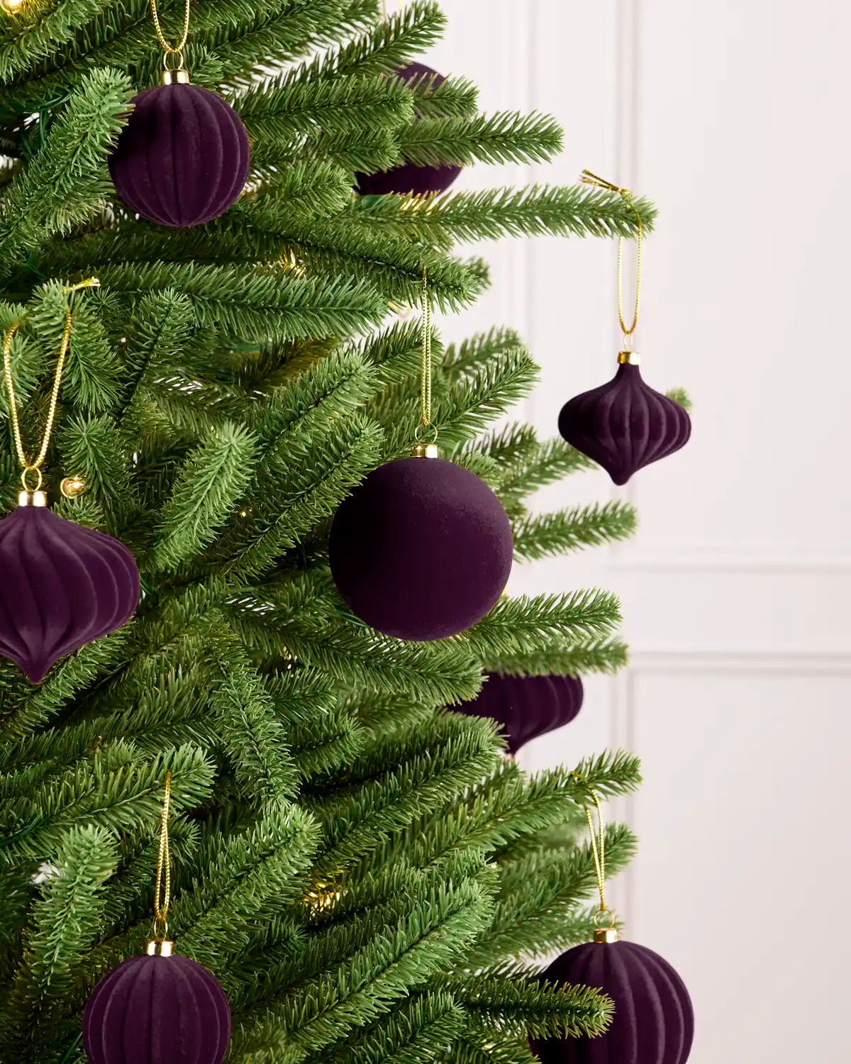 Purple velvet baubles decorating a Christmas tree, featuring soft purple velvet baubles