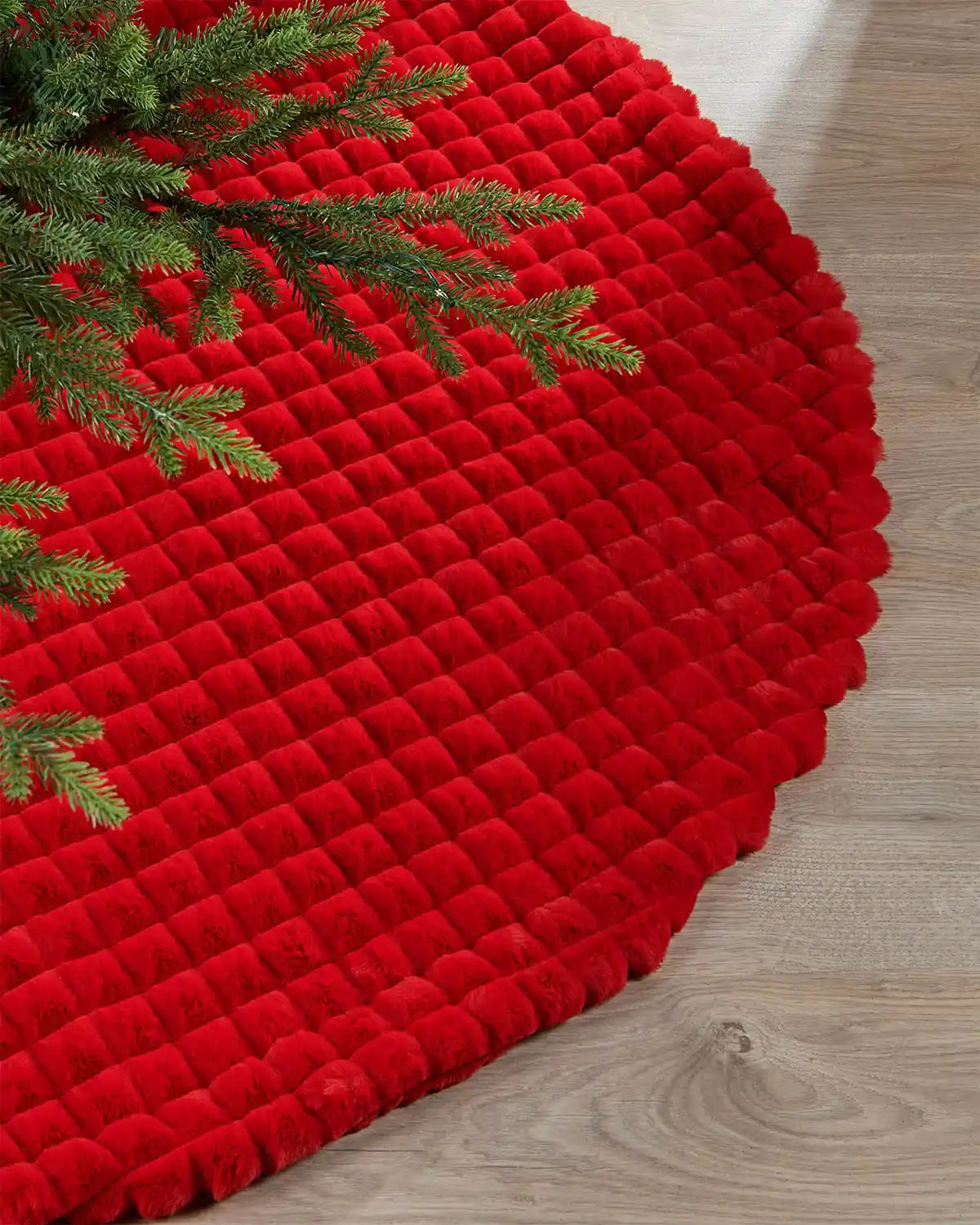 Red faux fur diamond tree skirt edge on light wooden flooring highlighting the soft texture of the skirt
