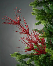 Red glitter firework spray in Christmas tree in front of grey background