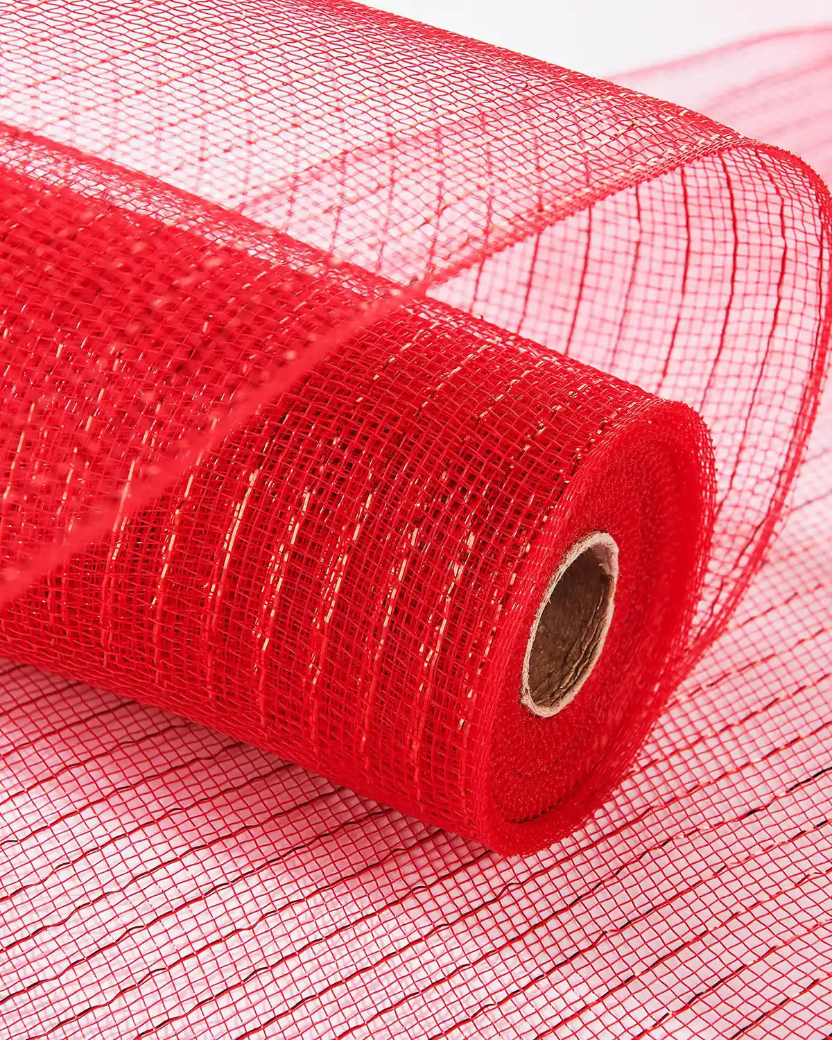 Red mesh fabric roll laying on more red fabric on a white table