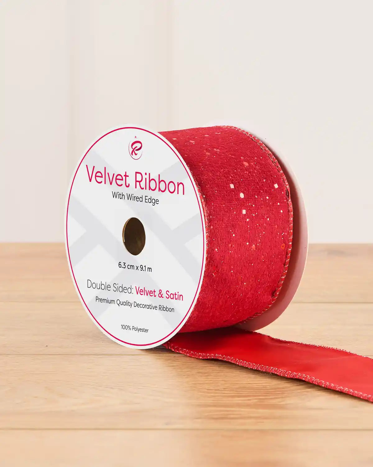 Red sequin ribbon on a wooden table against a light background