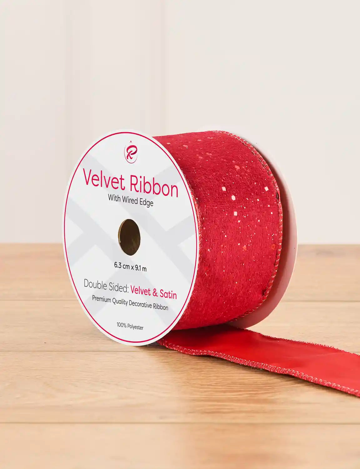 Red sequin ribbon on a wooden table against a light background